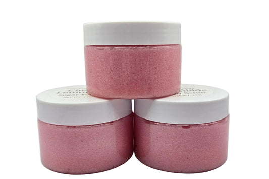 Three pink jars with white lids.